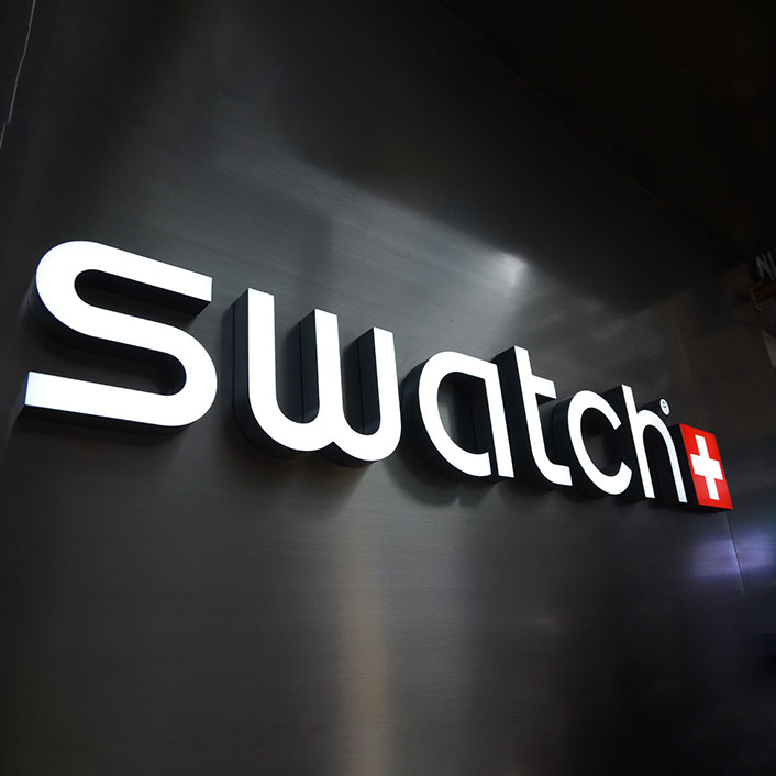 White illuminated acrylic channel letters on a dark wall